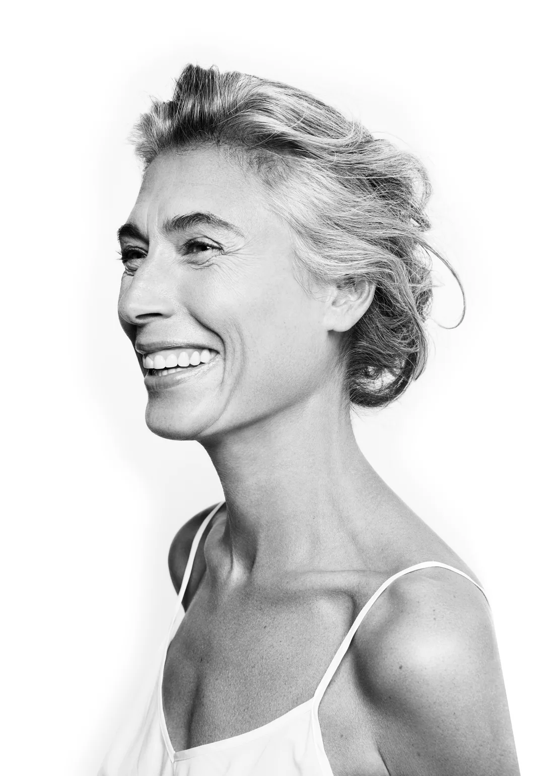 A woman in midlife smiling, in profile